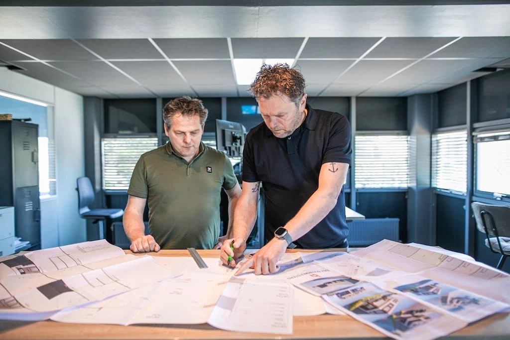 Jurgen en Pascal Kok overleggen over een tekening